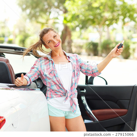 Woman standing near a convertible with keys Woman standing near a convertible with keys 27915066