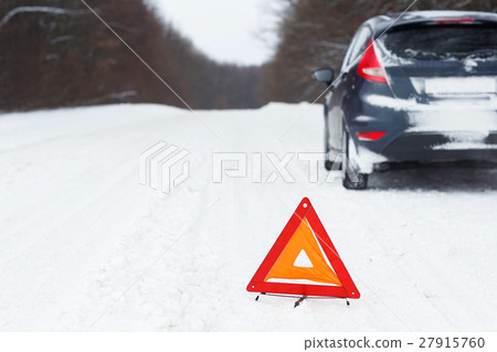 Closeup of red warning triangle with a broken car 27915760