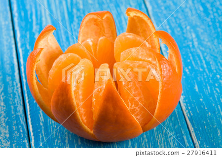 one peeled tangerine on a blue wooden background one peeled tangerine on a blue wooden background 27916411