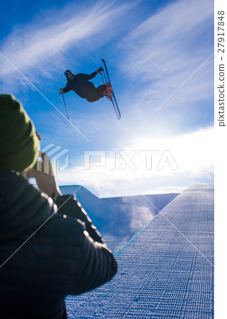 Photographer takes photo of halfpipe skier doing a Photographer takes photo of halfpipe skier doing a 27917848