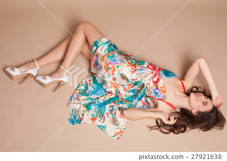 beautiful girl in colored dress lying on floor beautiful girl in colored dress lying on floor 27921638