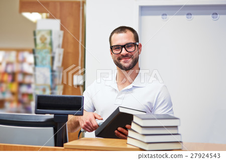 Salesman at the checkout in a bookstore 27924543
