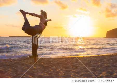 Woman practicing yoga on sea beach at sunset. 27926637