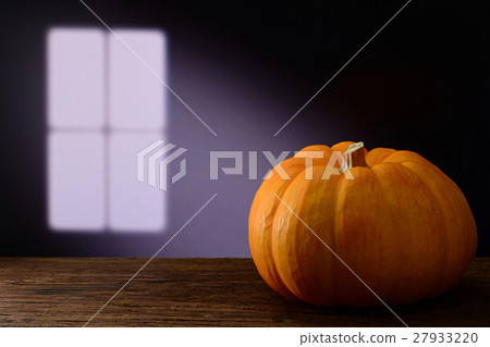 pumpkin on wooden table with window light 27933220
