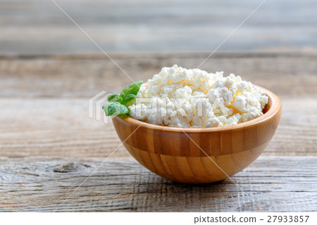 Homemade cottage cheese in a wooden bowl. 27933857