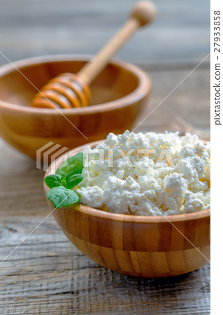 Fresh cottage cheese in wooden bowl. 27933858