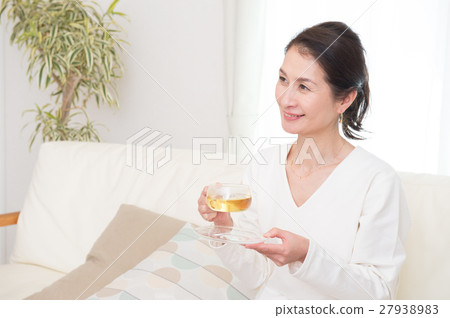 在客廳優雅地喝茶的中年女人 在客廳優雅地喝茶的中年女人 27938983
