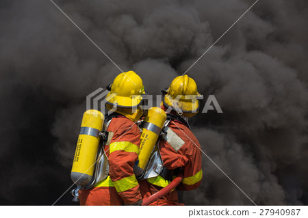 two firemen encounter with fire and black smoke two firemen encounter with fire and black smoke 27940987
