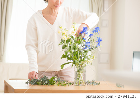 Middle aged women who live beautiful flowers in the living room 27941123