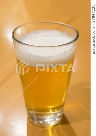 A glass of beer on the wood table A glass of beer on the wood table 27947226