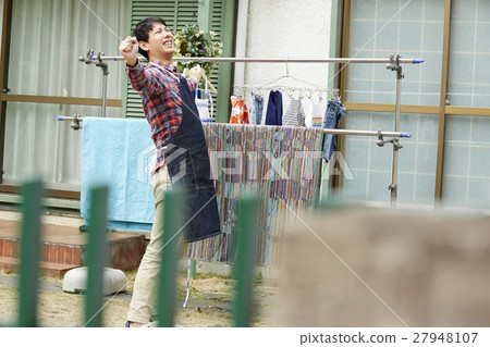 Male husband who hangs up the laundry 27948107