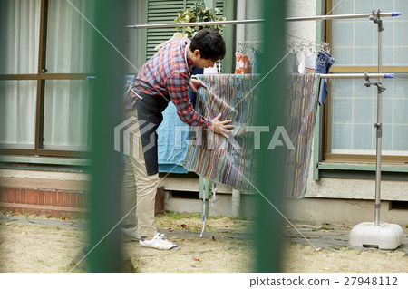 Male husband who hangs up the laundry 27948112
