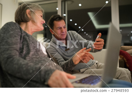 Senior couple with laptop and smartphone sitting Senior couple with laptop and smartphone sitting 27948593