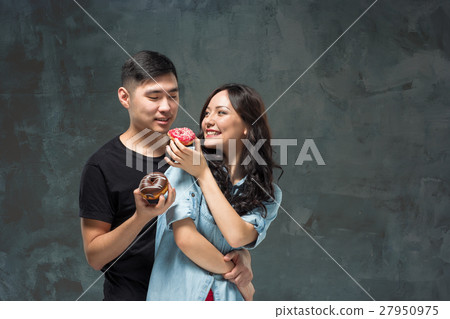 Young asian couple enjoy eating of sweet colorful Young asian couple enjoy eating of sweet colorful 27950975