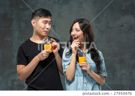 young pretty Asian couple with  glasses of Orang 27950976