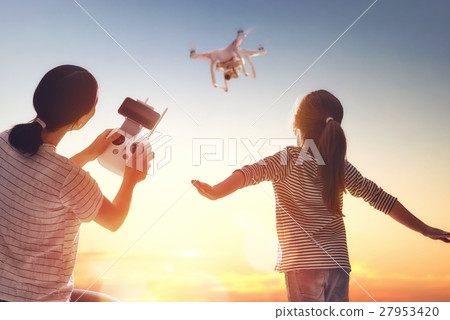 Kid and mom playing with drone 27953420