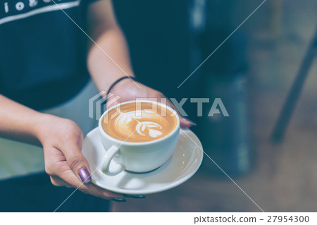 Women hands holding fresh coffee or latte art Women hands holding fresh coffee or latte art 27954300