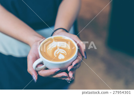 Women hands holding fresh coffee or latte art 27954301