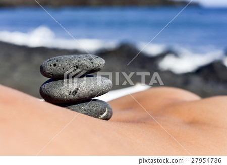 stones on the back of a man on the beach stones on the back of a man on the beach 27954786