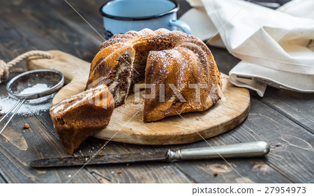 Marble cake cup of coffee and powder sugar . 27954973