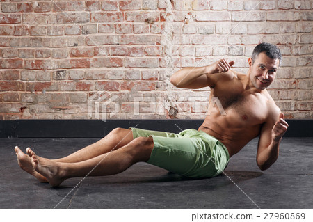 Young fit man exercising in a gym on old red Young fit man exercising in a gym on old red 27960869