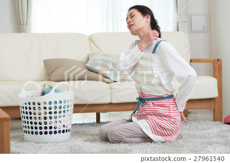 A middle-aged woman with shoulder stiffness that collapses laundry in the living room A middle-aged woman with shoulder stiffness that collapses laundry in the living room 27961540