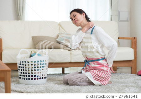 A middle-aged woman with shoulder stiffness that collapses laundry in the living room A middle-aged woman with shoulder stiffness that collapses laundry in the living room 27961541