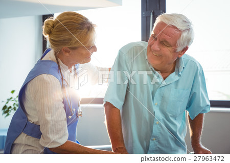 Nurse taking care of a senior man Nurse taking care of a senior man 27963472