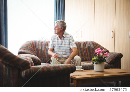 Senior man sitting on a couch Senior man sitting on a couch 27963473