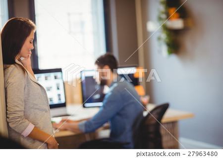 Graphic designer talking on mobile phone Graphic designer talking on mobile phone 27963480