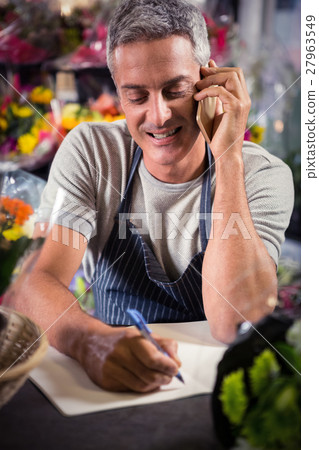 Male florist taking order on mobile phone Male florist taking order on mobile phone 27963549