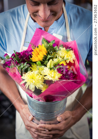 Male florist smelling flower 27963602