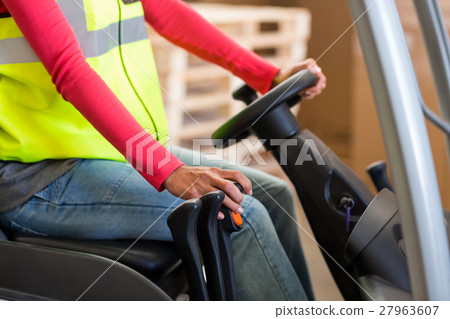 Close up of worker is driving a pallet truck Close up of worker is driving a pallet truck 27963607