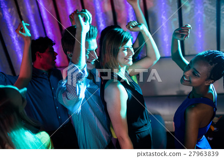 Group of smiling friends dancing on dance floor Group of smiling friends dancing on dance floor 27963839