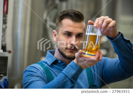 Close-up of brewer testing beer 27963931
