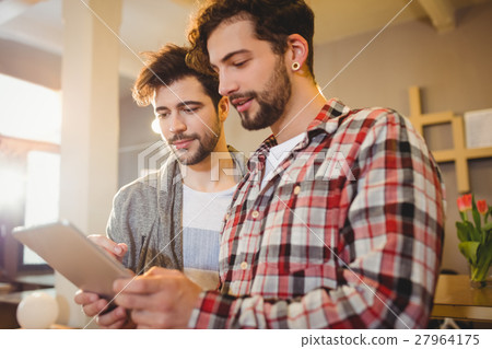 Graphic designer using digital tablet with his coworker 27964175