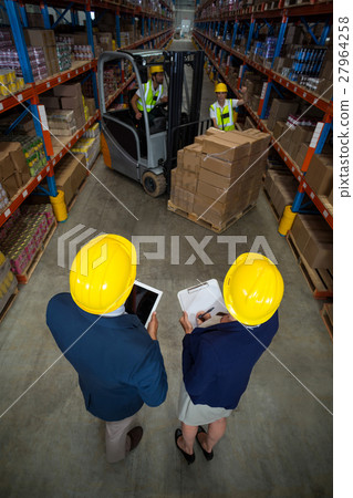 High angle view of manager wearing hard hat and looking workers 27964258