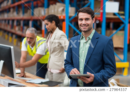 Focus on manager is smiling and holding a tablet in front of his colleagues 27964337