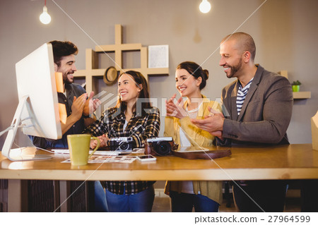 Team of graphic designers applauding a colleague 27964599