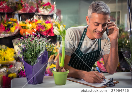 Male florist taking order on mobile phone 27964726