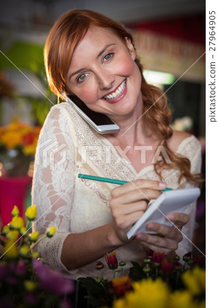 Female florist taking order on mobile phone Female florist taking order on mobile phone 27964905
