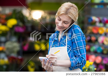 Female florist taking order on mobile phone 27965066