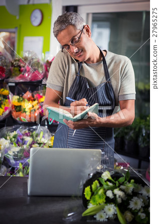 Male florist taking order on mobile phone 27965275