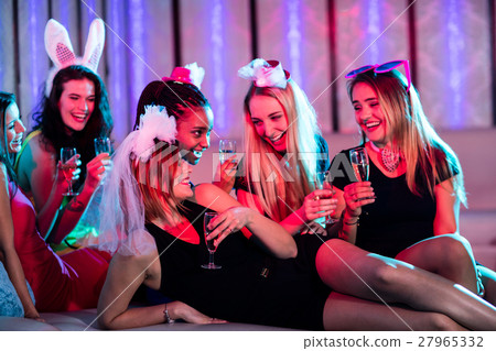 Group of women interacting while having a glass of champagne 27965332
