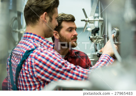 Maintenance workers examining pressure Maintenance workers examining pressure 27965483