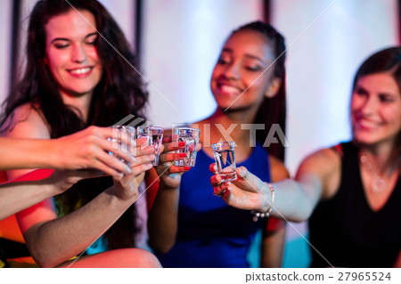 Group of friends toasting tequila shot glasses 27965524