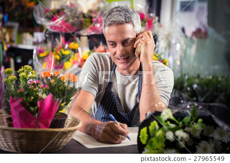Male florist taking order on mobile phone 27965549