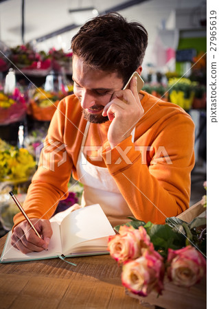 Male florist taking order on mobile phone 27965619