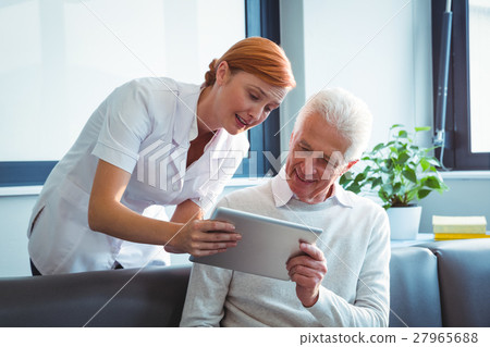 Nurse and senior man using a digital tablet Nurse and senior man using a digital tablet 27965688