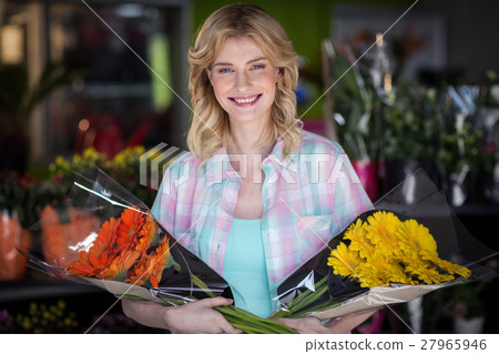 Happy female florist holding flower bouquet Happy female florist holding flower bouquet 27965946